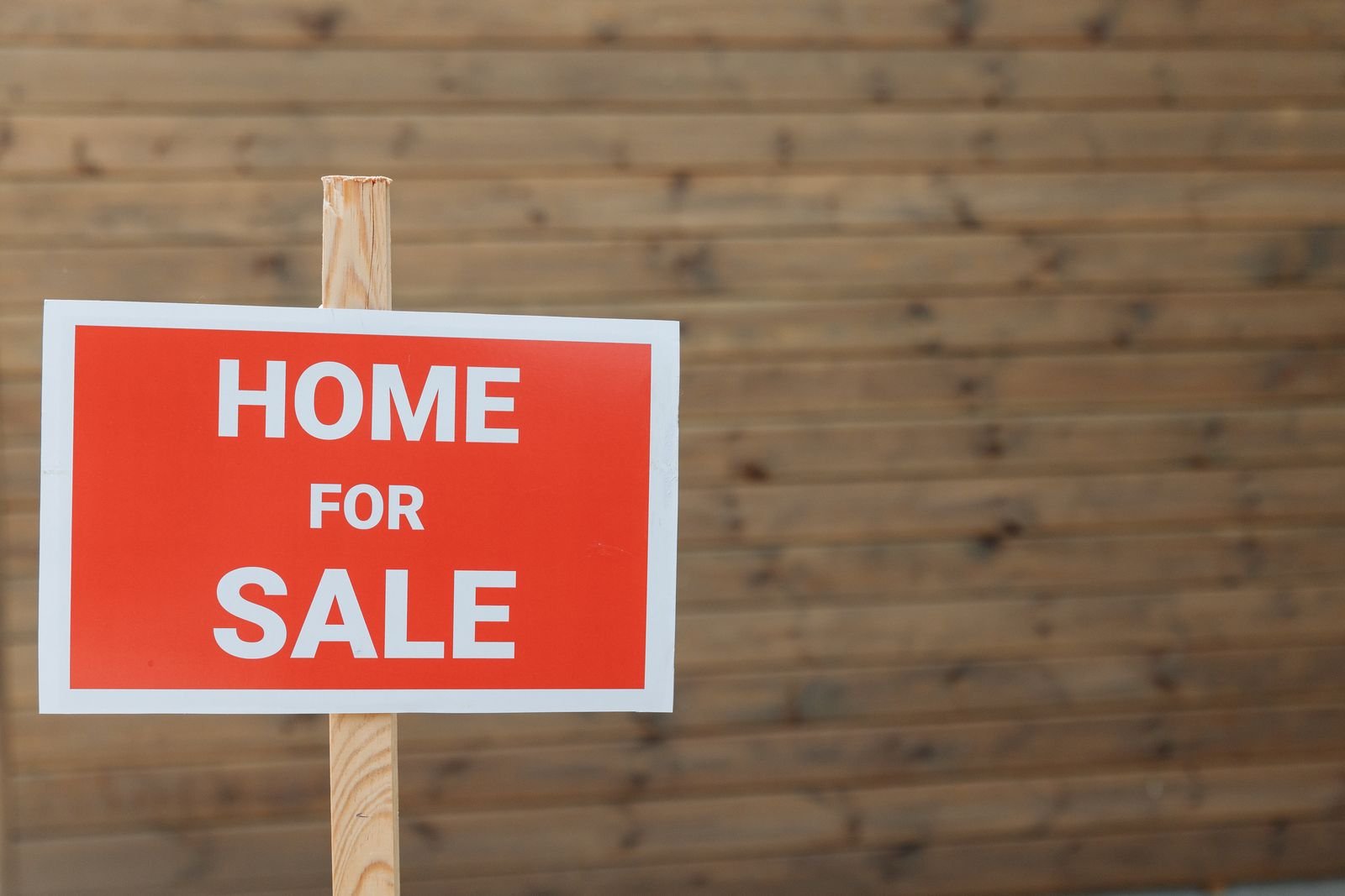 A home for sale sign in front of a house